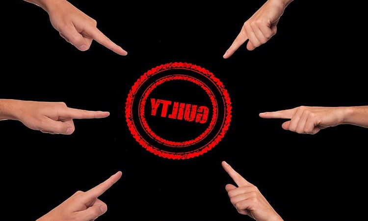 Fingers pointing at the word "Guilty".