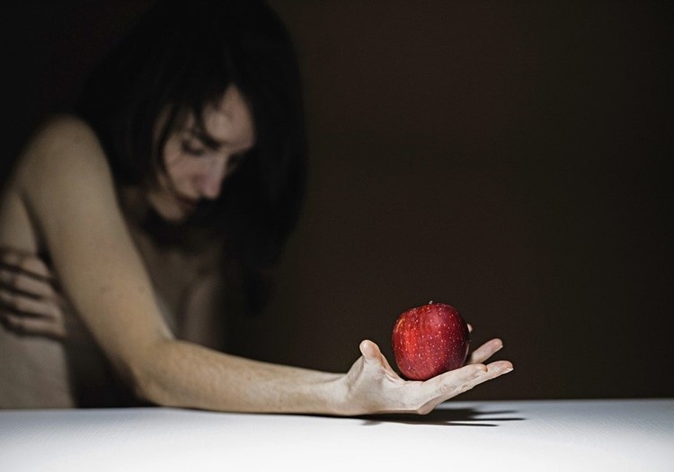 A woman holding an apple in her hand.