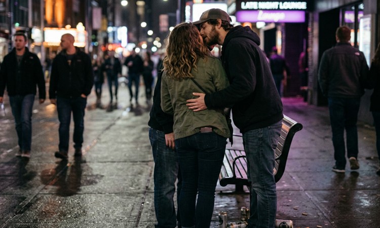 Two men and a woman kissing each other.
